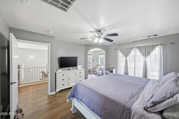 a spacious bedroom with a bed and a flat screen tv