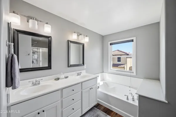 a bathroom with a tub a sink and mirror