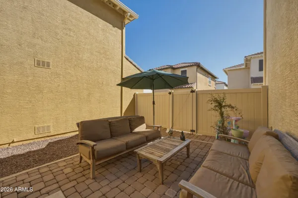 a view of a terrace with furniture and umbrella