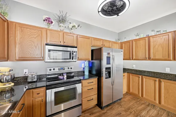 a kitchen with stainless steel appliances granite countertop a refrigerator and a stove top oven