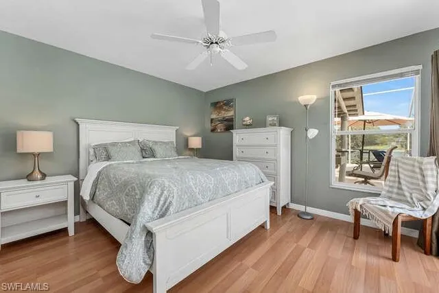 a spacious bedroom with a bed and wooden floor