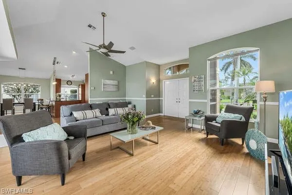 a living room with furniture dining area and a chandelier