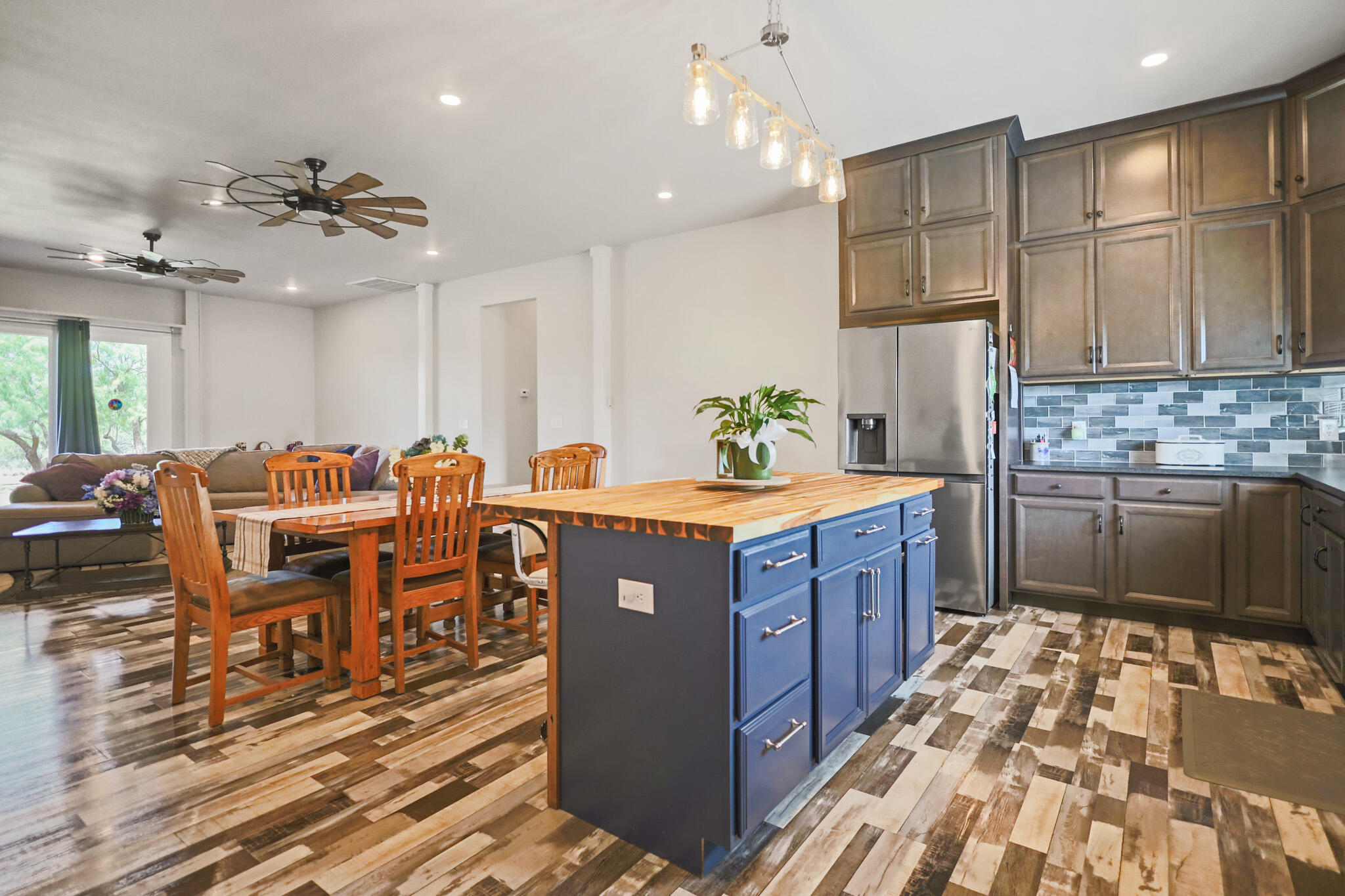 301 Fagan Road Snyder, TX 79549 - Photo 35 of 102 a kitchen with stainless steel appliances granite countertop a refrigerator a sink dishwasher and a dining table with wooden floor