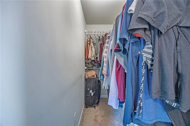 a view of walk in closet with clothes