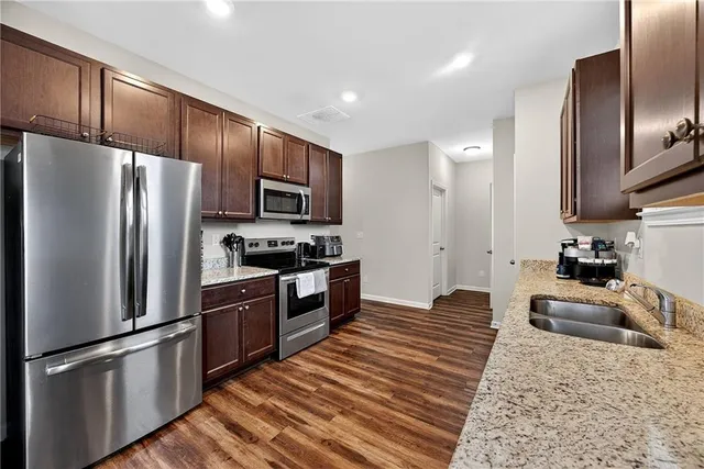 a kitchen with stainless steel appliances granite countertop a refrigerator stove and oven