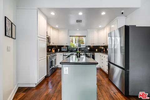 a view of a white house with a big yard and porch