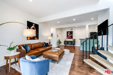 a living room with furniture and a wooden floor