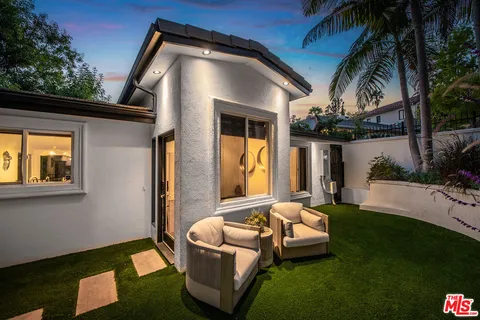 a view of a patio with couches table and chairs and potted plants