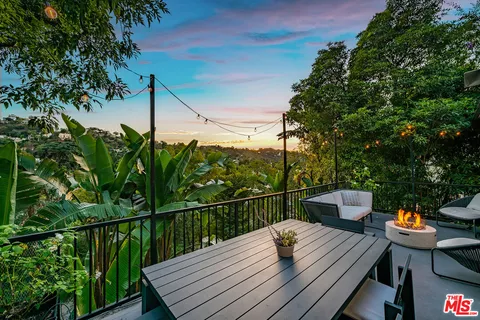 a living room with wooden floor and a chandelier