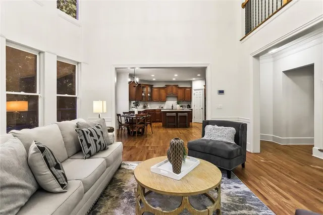 a view of a livingroom with wooden floor and a bathroom
