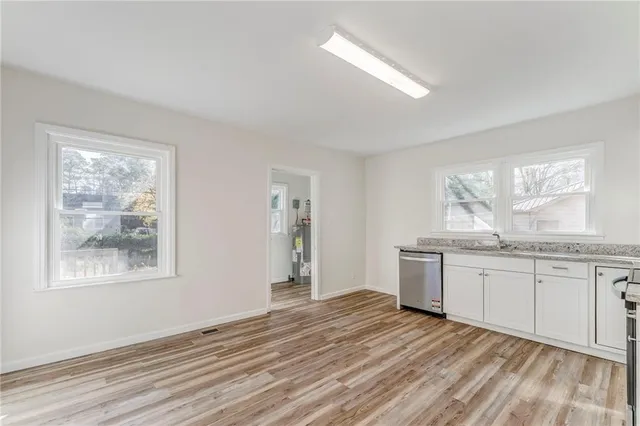 a bathroom with a granite countertop sink and a window