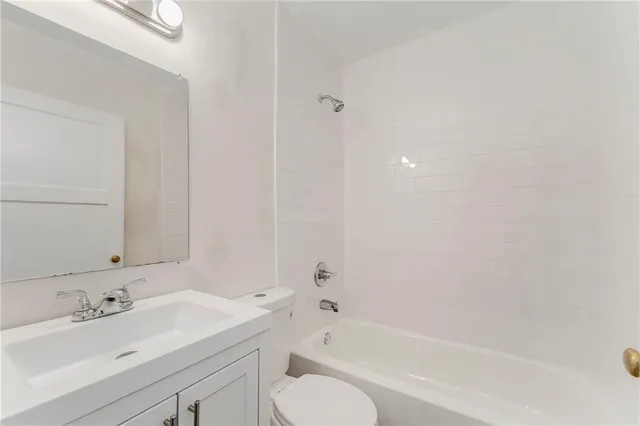 a bathroom with a bathtub shower sink vanity and toilet
