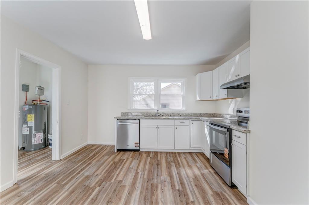 535 1st Street Northeast Rome, GA 30161 - Photo 9 of 34 a kitchen with granite countertop a stove top oven sink and cabinets