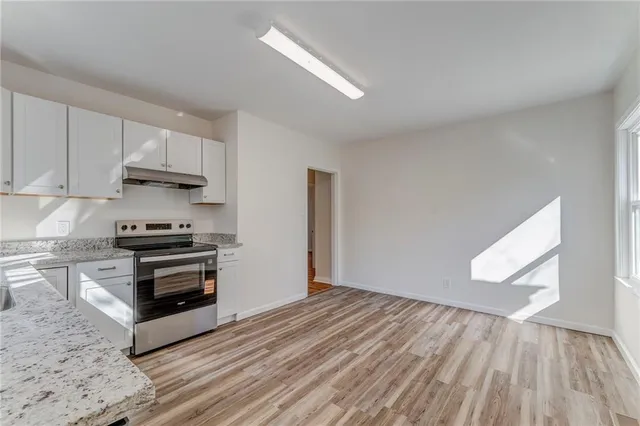 a kitchen with wooden floors and a stove top oven