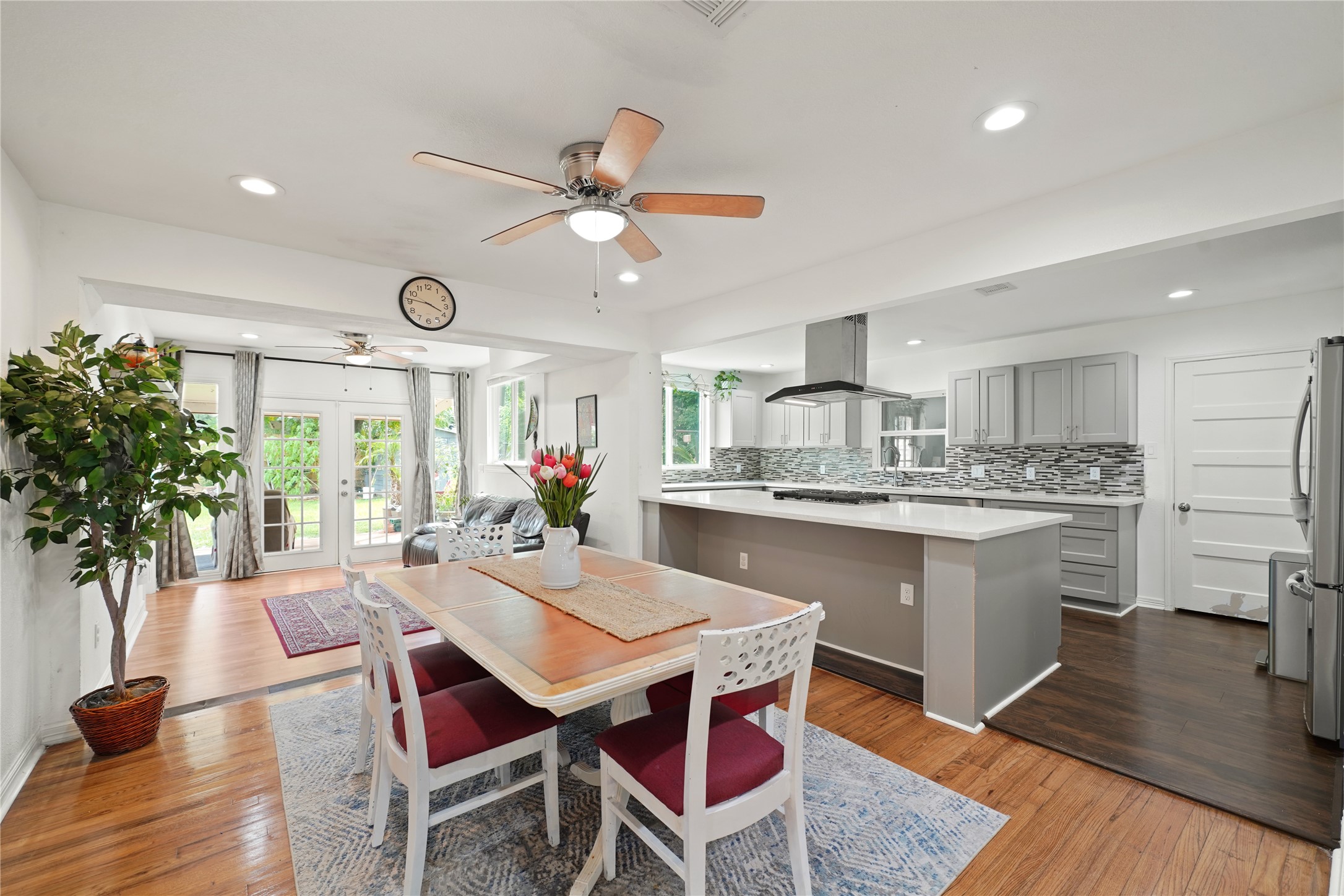 a kitchen with a dining table chairs sink and white cabinets