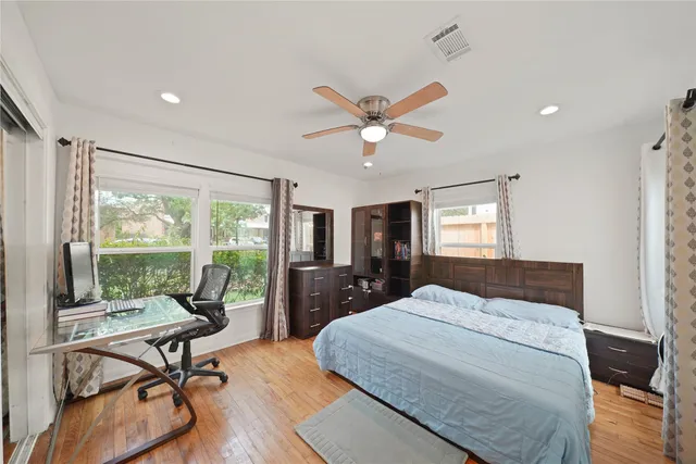 a bedroom with a bed large window and a balcony