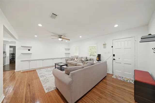 a living room with furniture and a wooden floor