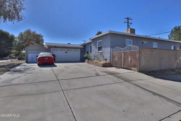 a front view of a house with cars