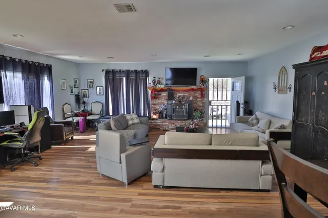 a living room with furniture flat screen tv and large window