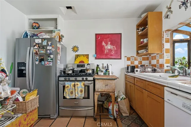 a kitchen with stainless steel appliances a stove a refrigerator and cabinets