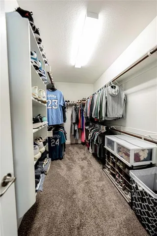 walk in closet with clothes and shoes