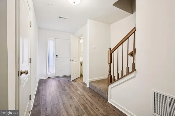 a view of a hallway with wooden floor and staircase