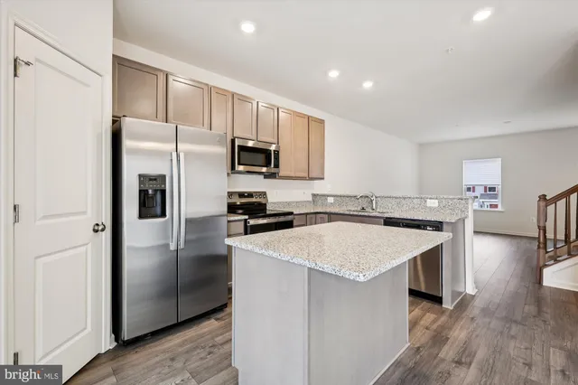 a kitchen with a refrigerator a sink and cabinets