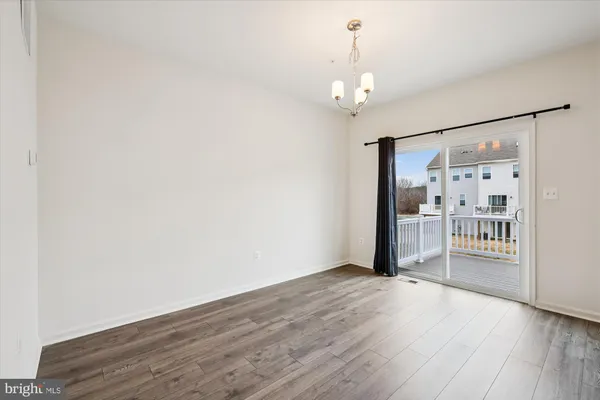 a view of a hallway with wooden floor and a living room
