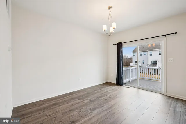 a view of a hallway with wooden floor and a living room