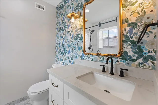 a bathroom with a sink a toilet and a mirror