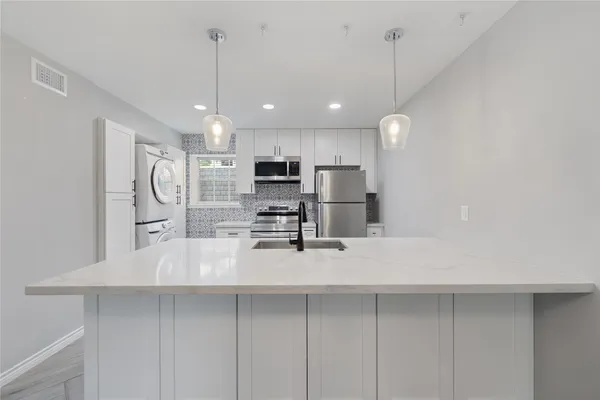 a kitchen with stainless steel appliances a refrigerator sink and microwave
