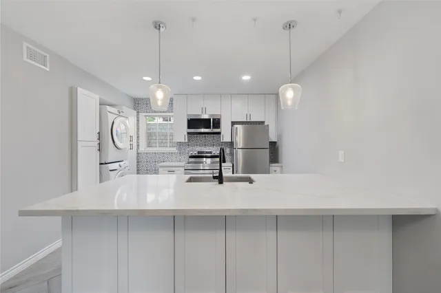 a kitchen with stainless steel appliances a refrigerator sink and microwave