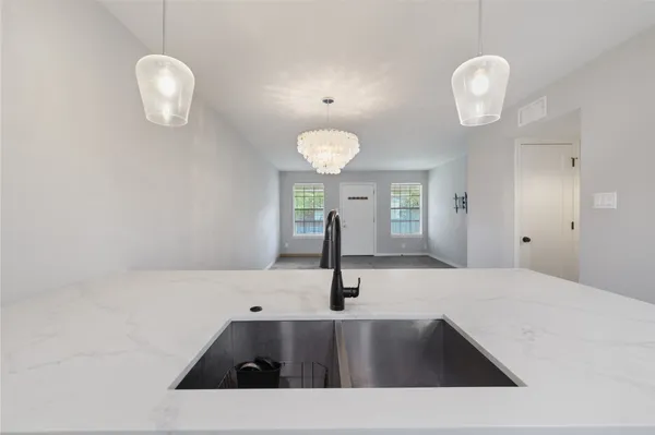 a view of a kitchen with a sink and chandelier