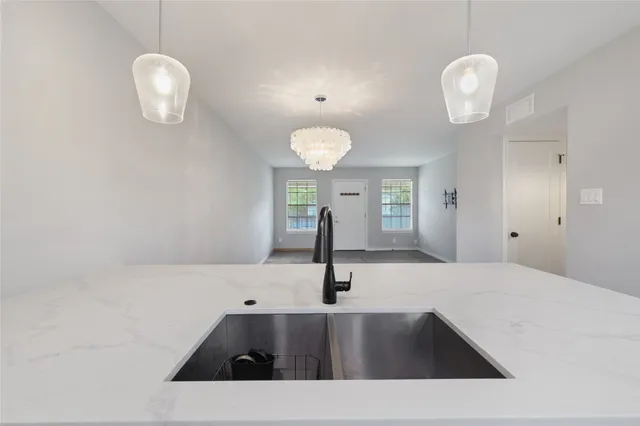 a view of a kitchen with a sink and chandelier