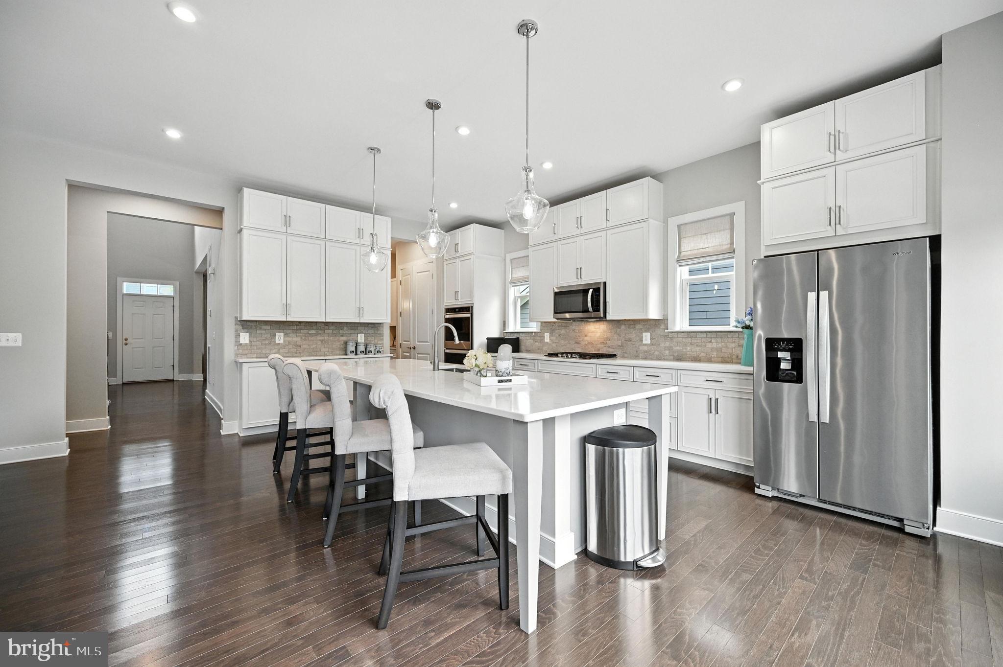 40960 River Cane Place Aldie, VA 20105 - Photo 3 of 54 a kitchen with stainless steel appliances a dining table chairs refrigerator and microwave