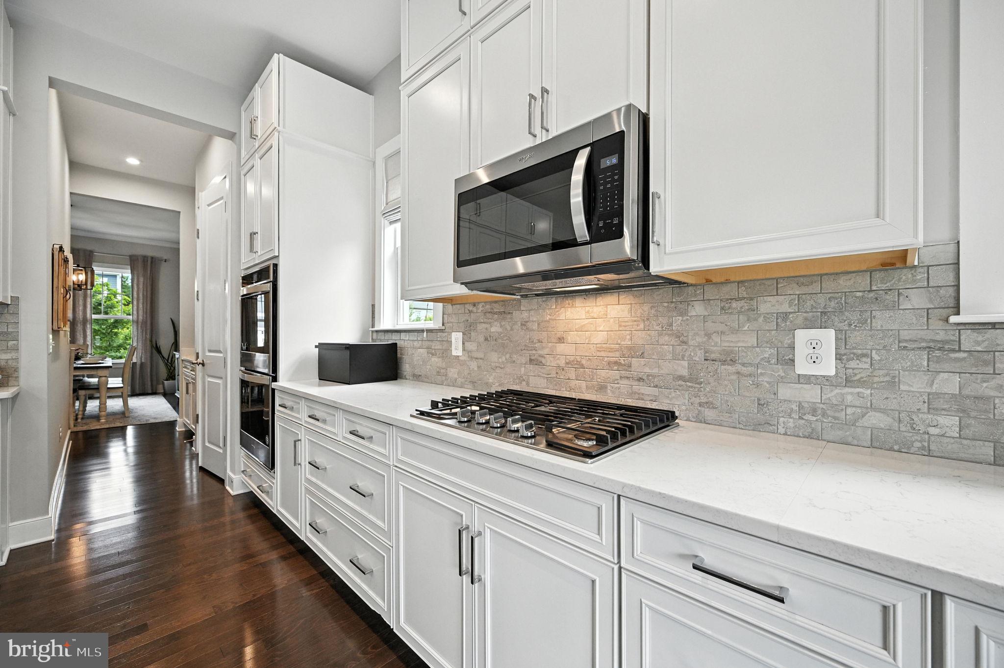 40960 River Cane Place Aldie, VA 20105 - Photo 4 of 54 a kitchen with stainless steel appliances white cabinets and stove