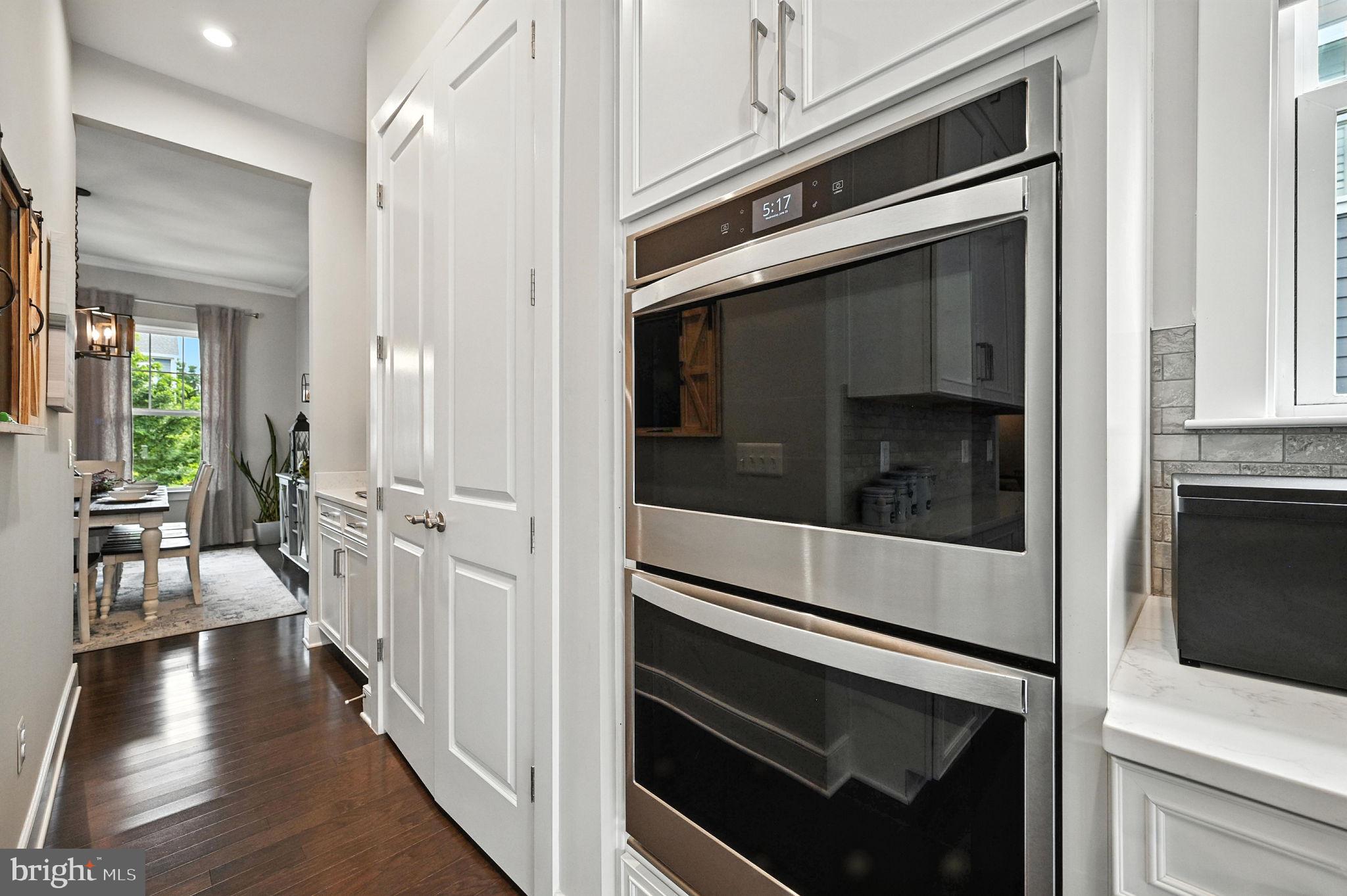 40960 River Cane Place Aldie, VA 20105 - Photo 5 of 54 a hallway with white cabinets and black appliances