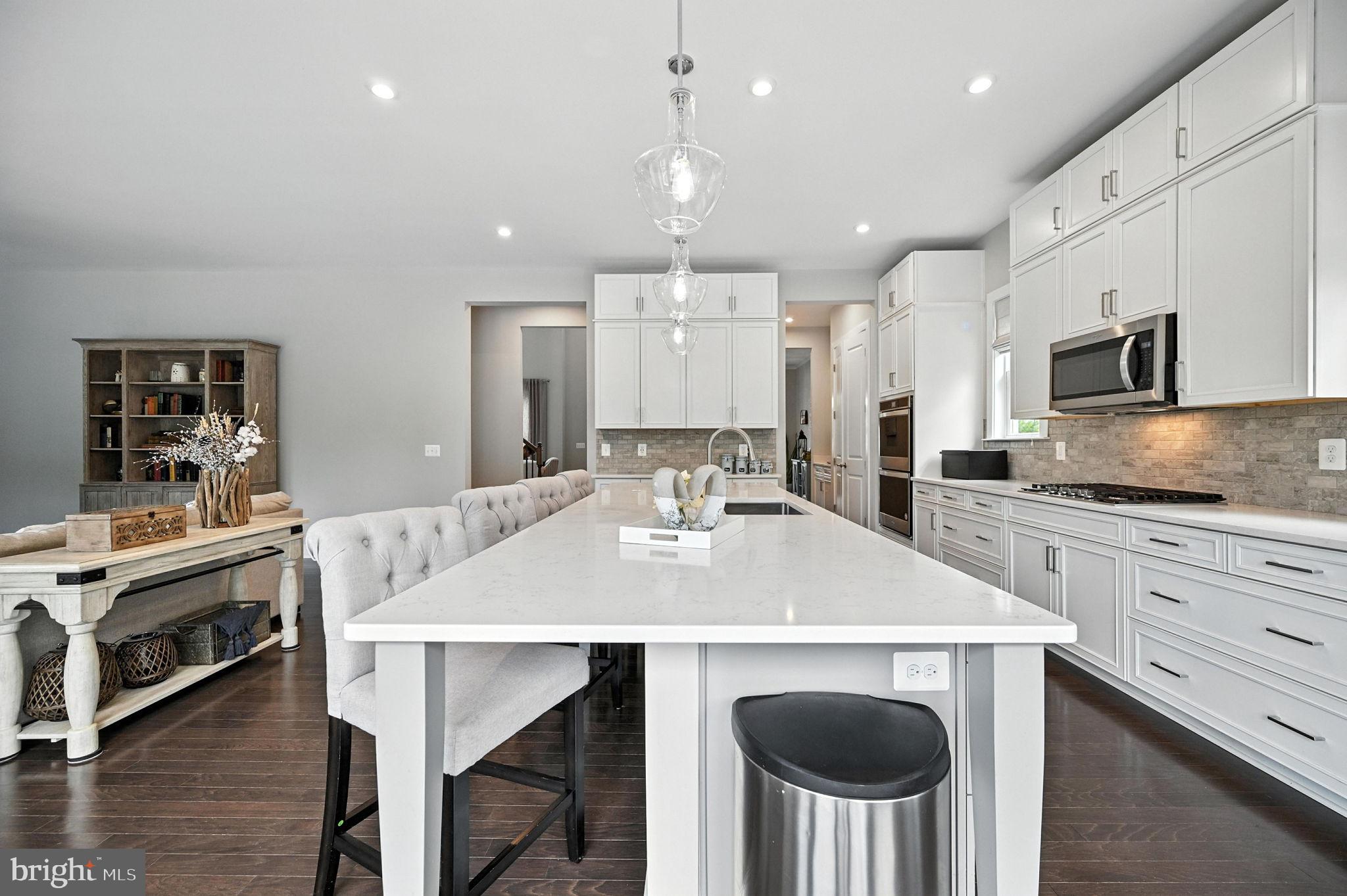 40960 River Cane Place Aldie, VA 20105 - Photo 9 of 54 a kitchen with kitchen island a stove a table and chairs