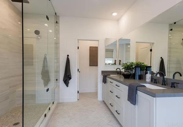 a bathroom with a double vanity sink mirror and shower