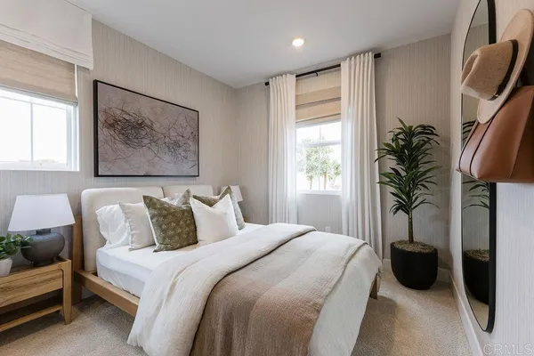 a bedroom with a bed a couch and a potted plant