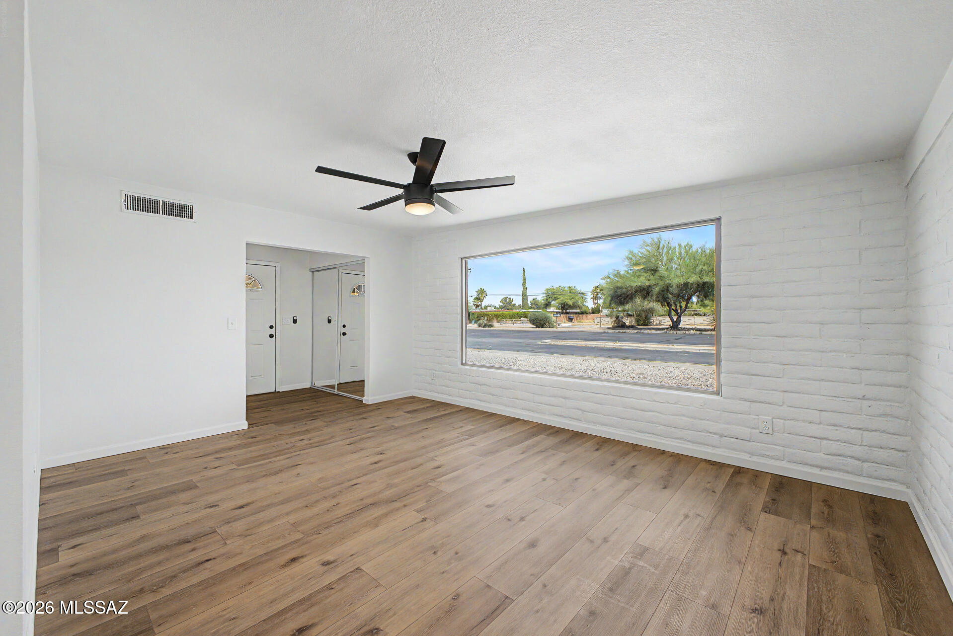 3402 South Kolb Road Tucson, AZ 85730 - Photo 8 of 32 a view of empty room with wooden floor and window