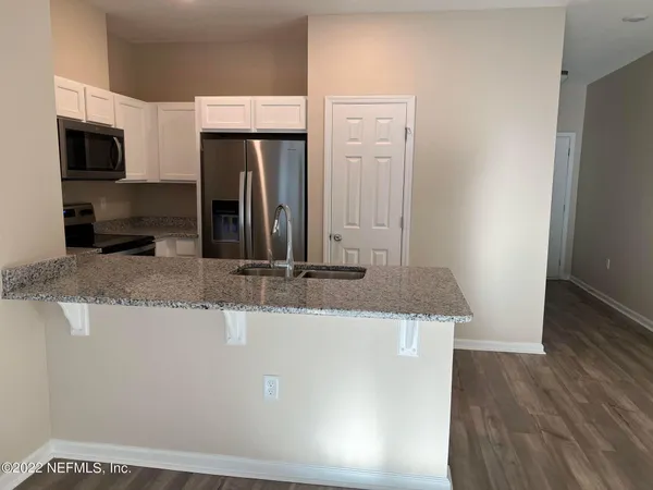 a kitchen with kitchen island microwave and refrigerator