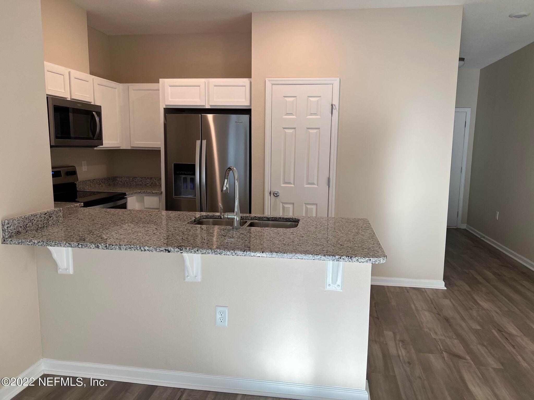 11795 Junegrass Road Jacksonville, FL 32258 - Photo 2 of 15 a kitchen with kitchen island microwave and refrigerator