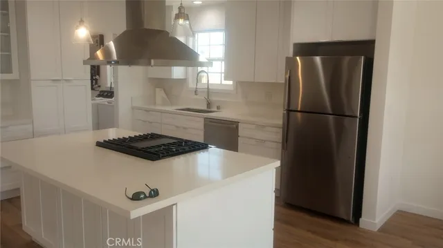 a kitchen with a stove a refrigerator and wooden floor