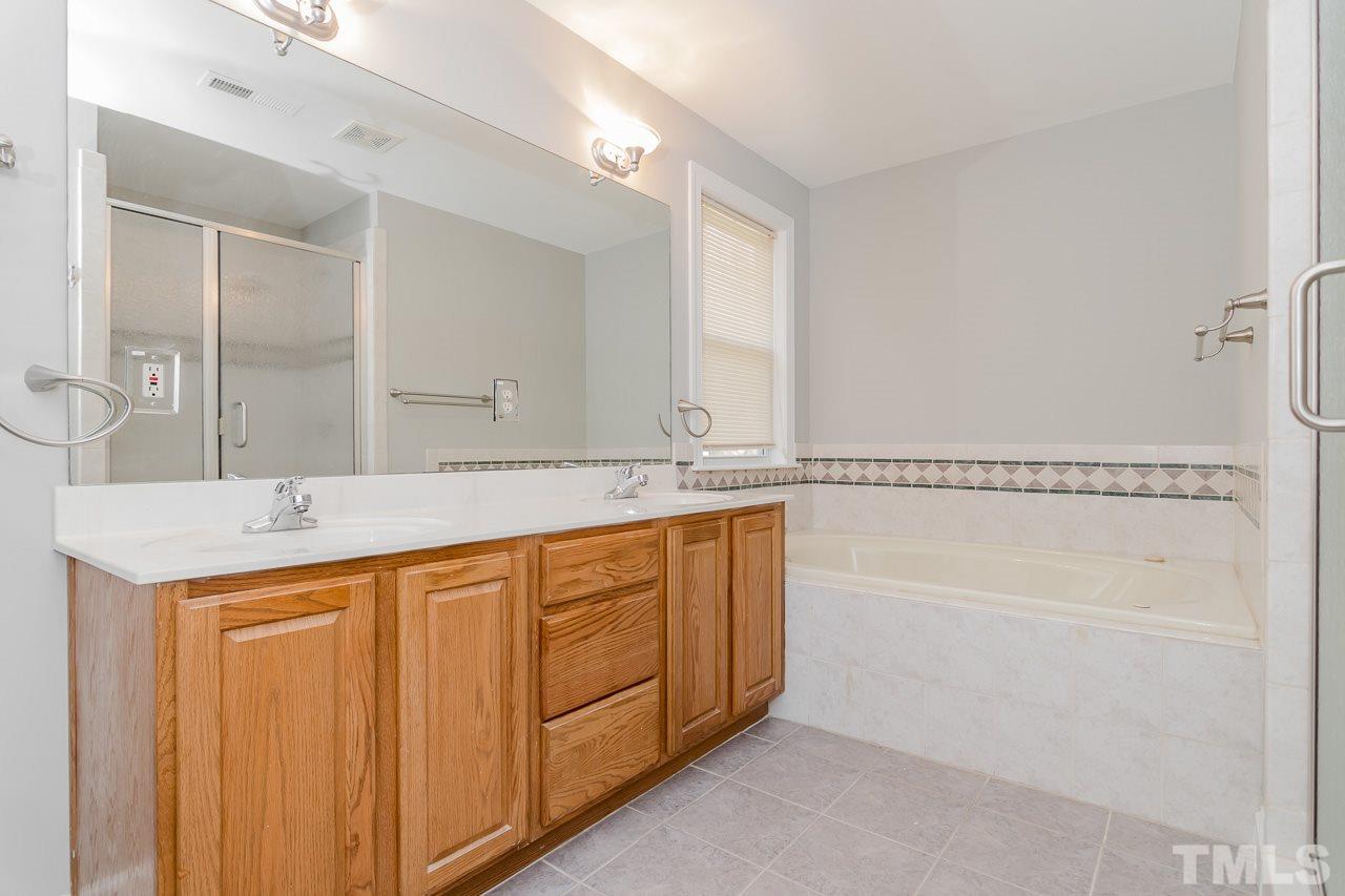 1404 Onslow Road Raleigh, NC 27606 - Photo 19 of 30 a spacious bathroom with a granite countertop sink and a mirror