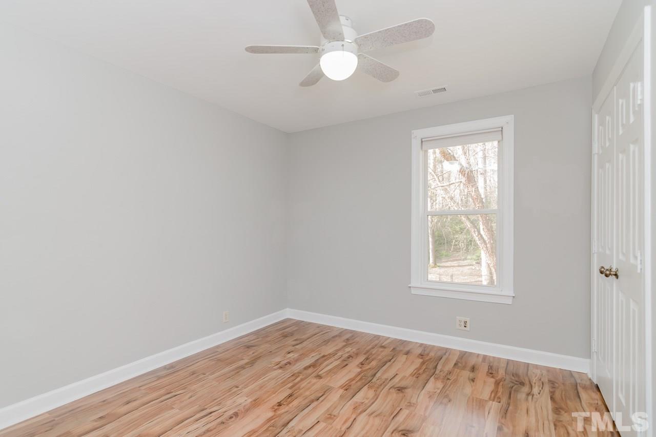 1404 Onslow Road Raleigh, NC 27606 - Photo 23 of 30 an empty room with wooden floor ceiling fan and windows