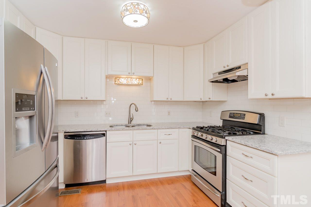 1404 Onslow Road Raleigh, NC 27606 - Photo 8 of 30 a kitchen with stainless steel appliances white cabinets and a stove