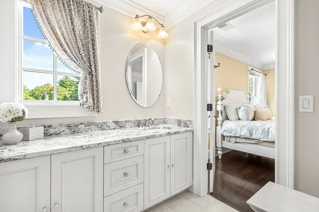 a en suite bathroom with a granite countertop double vanity sink and a mirror