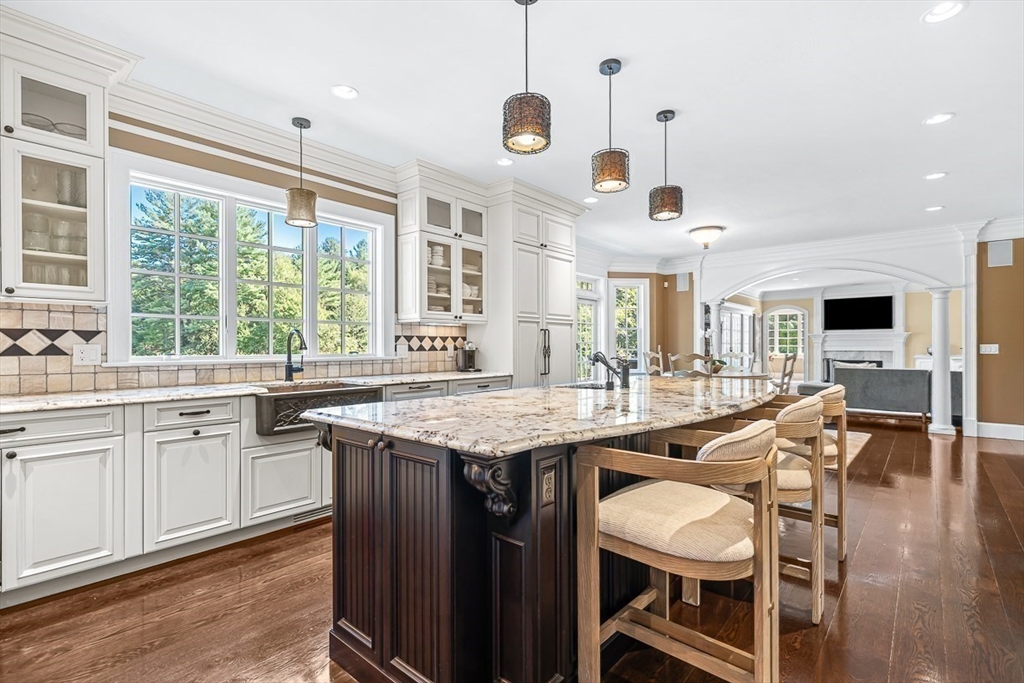33 Old Concord Road Lincoln, MA 01773 - Photo 7 of 42 a open kitchen with stainless steel appliances granite countertop a stove a sink dishwasher a dining table and chairs with wooden floor