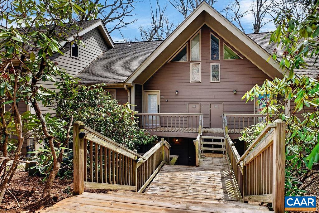 a view of a house with wooden deck and furniture